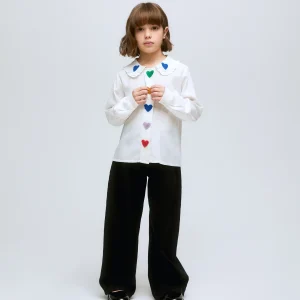 Camisa blanca con detalle de corazones multicolor y cuello con volantes.