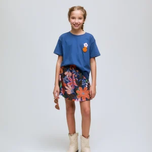 Camiseta azul de niña con bordado de flor.