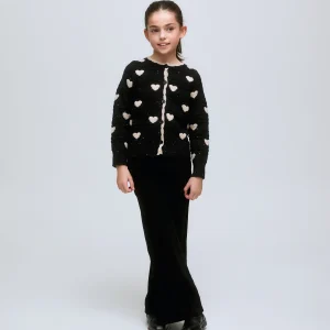 Cárdigan de niña negro con corazones blancos y botones frontales.