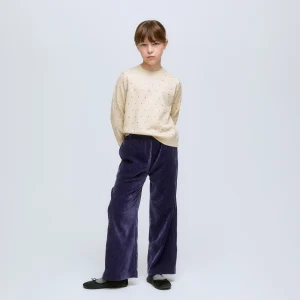 Jersey de niña de punto beige con pequeños apliques de brillos.